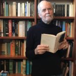 Brian Finney Author Photo Standing Library Holding Book